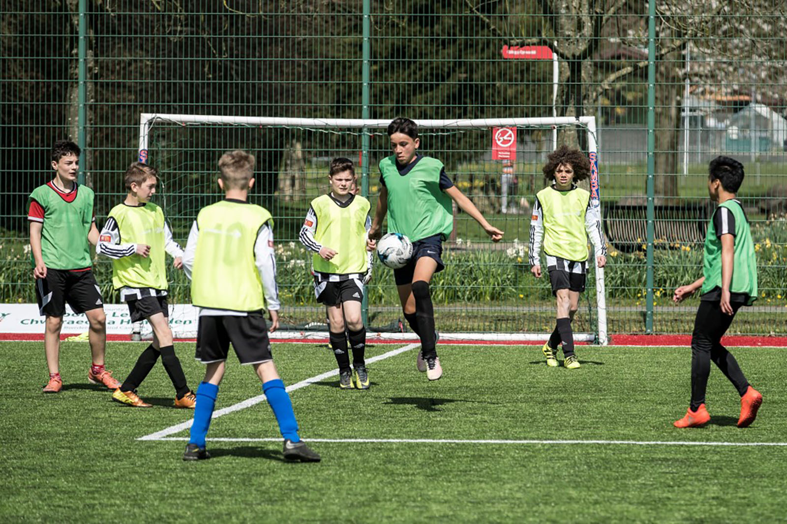 group of young boys playing football on an outside pitch group of young boys playing football on an outside pitch